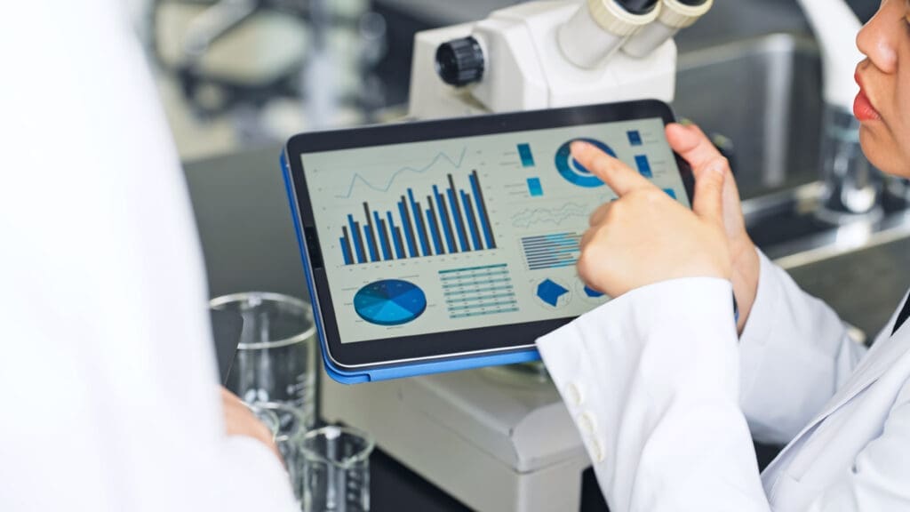 Group of researchers looking at tablet data in the lab. Research